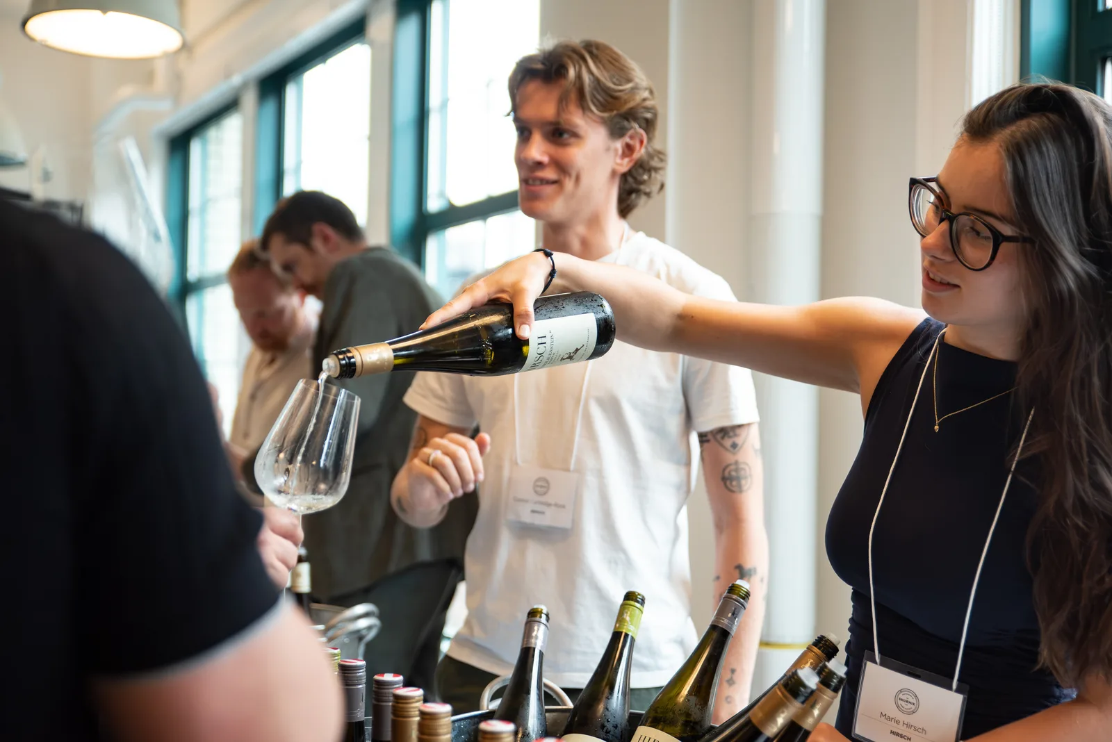 Woman pouring wine for a guest at a tasting table
